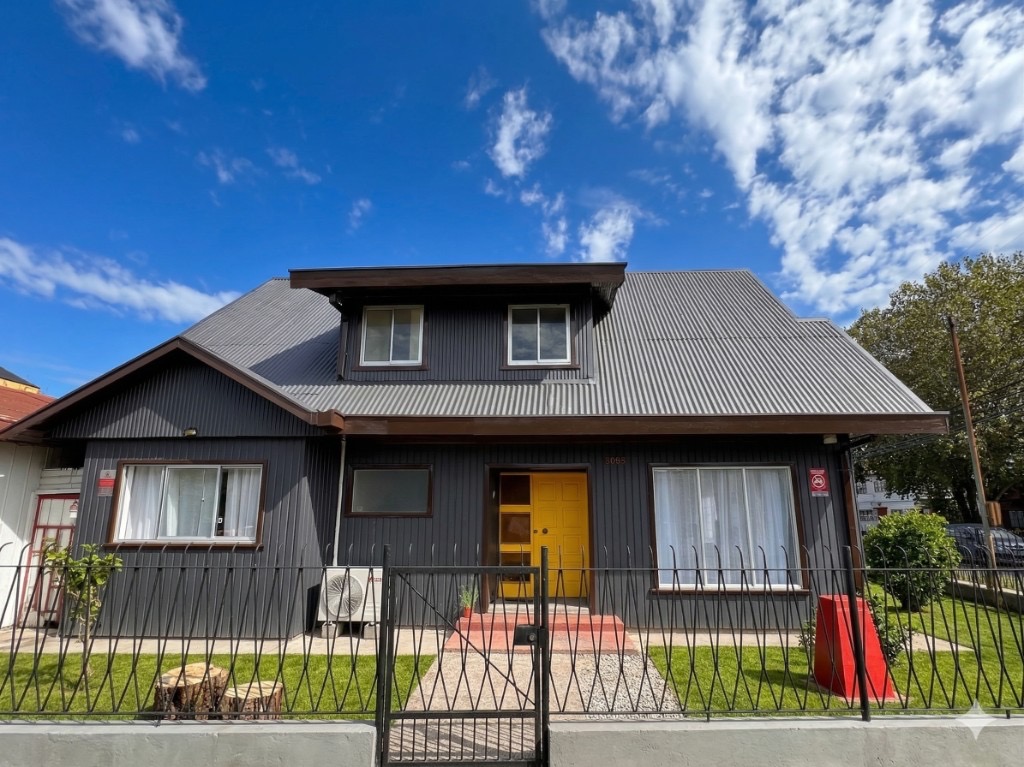Fachada del coliving Valdivia con puerta amarilla — imagen de referencia